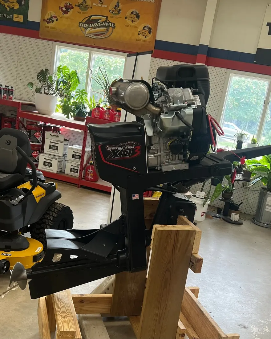 Yellow zero-turn mower on the service lift in the showroom